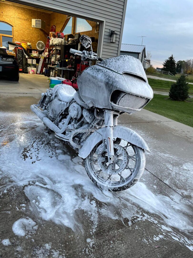 A motorcycle is covered in foam on the street.