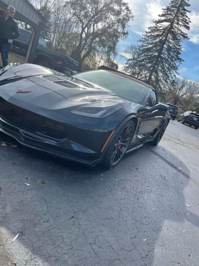 A black corvette parked on the side of a road.